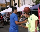 Ballplayer gets an assist from a KBPA volunteer during exhibition at Celebrate Kaimuki Kanikapila